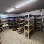 Überfüllter Kellerraum mit Regalen, Kartons und verschiedenem Gerümpel, ideal für eine professionelle Kellerentrümpelung.