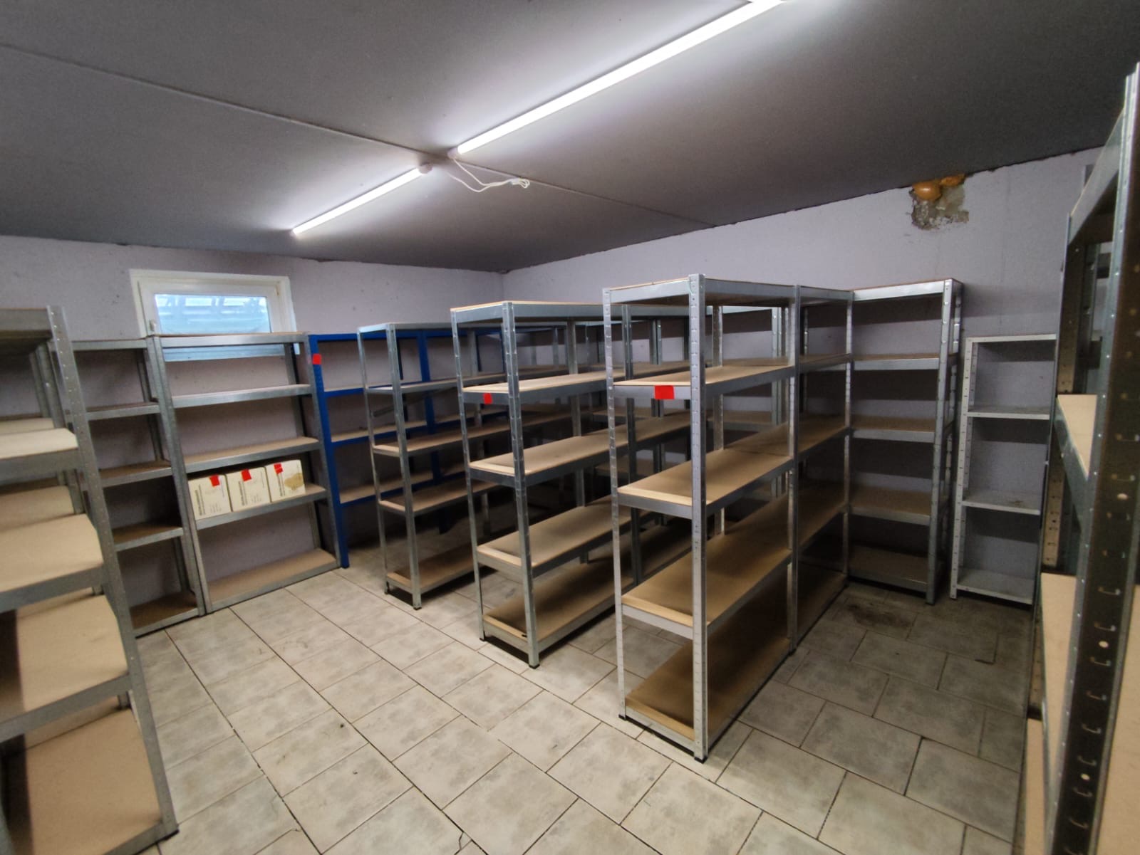 Überfüllter Kellerraum mit Regalen, Kartons und verschiedenem Gerümpel, ideal für eine professionelle Kellerentrümpelung.