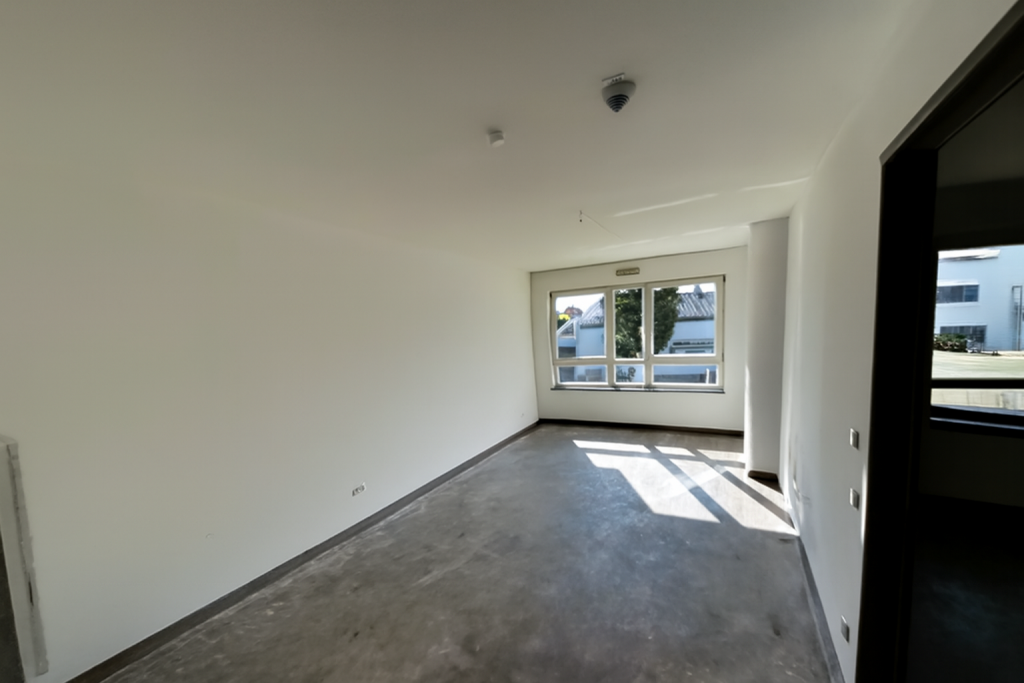 Wohnzimmer nach Entrümpelung, Boden entfernt, frisch gestrichene weiße Wände.