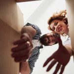 Glückliches Paar packt Kleidung aus Kartons in ihrem neuen Zuhause aus – Umzug